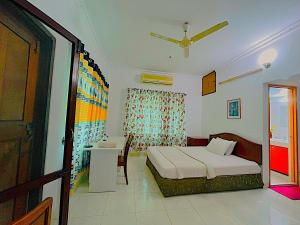 a bedroom with a bed and a table and a window at Maya Eco Guest House in Dhaka