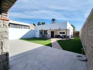 a white house with a green yard at Casa Mona MODERN Beach Home in Puerto Peñasco