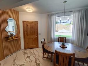 a dining room with a wooden table and a window at Casa Mona MODERN Beach Home in Puerto Peñasco