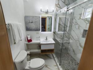 a bathroom with a toilet and a sink and a shower at Casa Mona MODERN Beach Home in Puerto Peñasco +12 photos