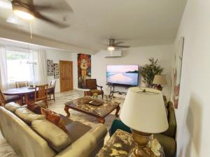 a living room with a couch and a tv at Casa Mona MODERN Beach Home in Puerto Peñasco