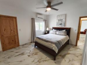 a bedroom with a bed and a ceiling fan at Casa Mona MODERN Beach Home in Puerto Peñasco