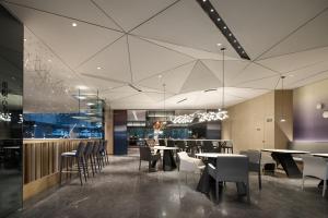 a restaurant with tables and chairs and a bar at Mercure Guilin Yangshuo Xingping in Guilin