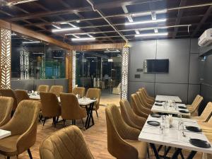 a restaurant with tables and chairs and a flat screen tv at Hotel Dev Vilas 600 Metres from Taj Mahal in Agra