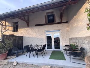 a patio with a table and chairs in front of a house at Appartement t4 évasion avec terrasse Week-end détente in Briord