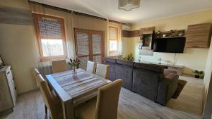 a living room with a table and a couch at Lotti City Apartman in Békéscsaba