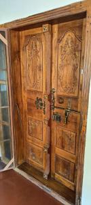 an old wooden door in a room at Villa in Chengannur in Māvelikara