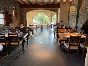 a restaurant with tables and chairs and a large window at Santa Llúcia Rupit in Rupit