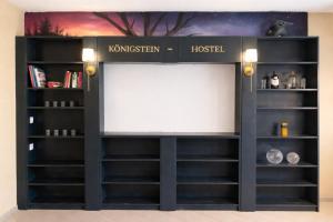 a black book shelf with a white screen at Königstein Hostel in Königstein an der Elbe