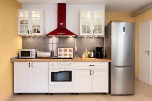 a kitchen with white cabinets and a stainless steel refrigerator at Königstein Hostel in Königstein an der Elbe