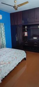 a bedroom with a bed and a blue wall at Villa in Chengannur in Māvelikara
