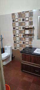 a bathroom with a toilet and a sink and a mirror at Villa in Chengannur in Māvelikara