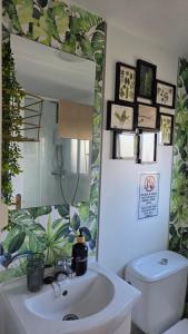 a bathroom with a sink and a mirror and a toilet at Area Parking Caravane in Seville +11 photos