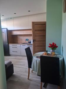 a kitchen with a table and chairs and a refrigerator at K&H Tarnów Centrum in Tarnów