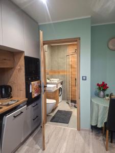 a kitchen with a door open to a bathroom at K&H Tarnów Centrum in Tarnów