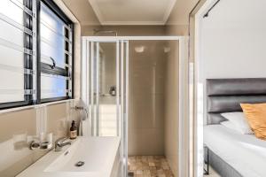 a bathroom with a shower and a sink and a bed at The Lighthouse in Cape Town +75 photos