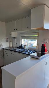 a kitchen with white cabinets and a stove top oven at Area Parking Caravane in Seville