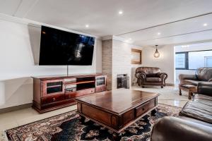 a living room with a tv and a coffee table at The Lighthouse in Cape Town