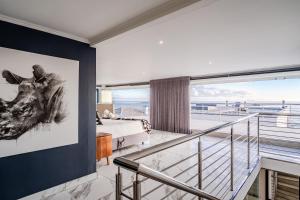 a bedroom with a bed and a view of the ocean at The Lighthouse in Cape Town