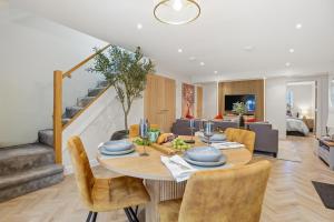 a dining room and living room with a table and chairs at The Luxe Pool House, Westoning in Westoning