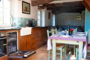 a kitchen with a table with a purple counter top at Carnac: Maison chaleureuse, calme proche plages in Carnac +33 photos