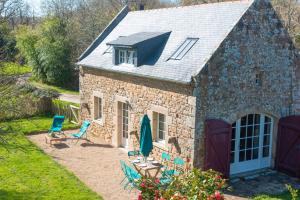 a stone cottage with chairs and a table at Carnac: Maison chaleureuse, calme proche plages in Carnac