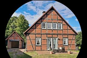 an old brick house with a garage in front at Ferienhaus in Clenzer Schweiz in Clenze