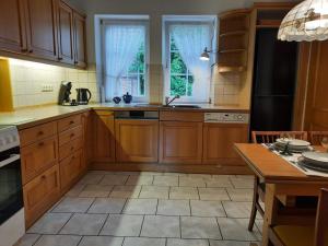 a kitchen with wooden cabinets and a large window at Ferienhaus in Clenzer Schweiz in Clenze +5 photos