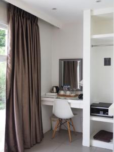 a room with a desk with a chair and a window at LeBlanc Hotel in Antipolo
