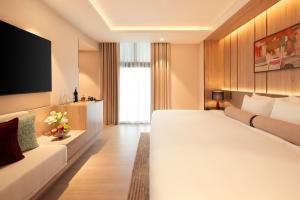 a hotel room with a large bed and a couch at The Auberg Collection Hotel in Ho Chi Minh City