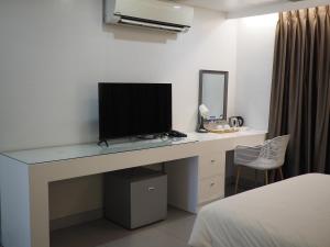 a desk with a television on top of it in a bedroom at LeBlanc Hotel in Antipolo