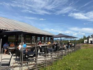 a group of people sitting at tables under umbrellas at Gesundaberget Lodge & Parstugor in Gesunda