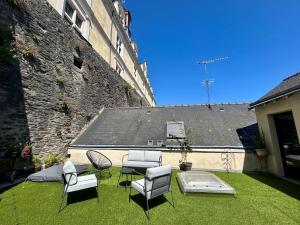 a yard with chairs and a table and a building at Logis Hotel du Maine in Laval
