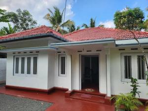 a small house with a red roof at Shan Inn Midigama in Midigama East