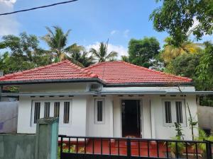 a white house with a red roof at Shan Inn Midigama in Midigama East