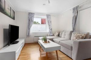 a living room with a couch and a tv at Apartment close to the mountain in Svolvær
