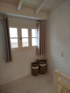 a room with two windows and two baskets at Casa del porto in Lákka +46 photos