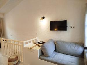 a living room with a couch and a tv on the wall at Casa del porto in Lákka