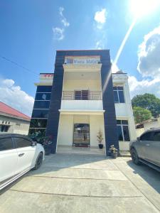 a white car parked in front of a building at Wisma Mutiara Syariah Langsa in Langsa
