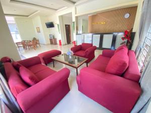 a living room with pink couches and a table at Wisma Mutiara Syariah Langsa in Langsa