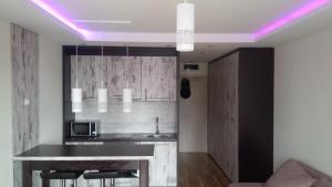 a kitchen with a bar with a purple lighting at Apartments Vanja i Vrh in Kopaonik