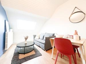 a living room with a table and a couch at L'Orchidée Marine, T2, 100m plage et du commando in Saint-Nazaire +25 photos