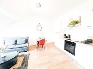 a kitchen and living room with a couch and a table at L'Orchidée Marine, T2, 100m plage et du commando in Saint-Nazaire