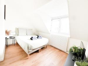 a white bedroom with a bed and a window at L'Orchidée Marine, T2, 100m plage et du commando in Saint-Nazaire