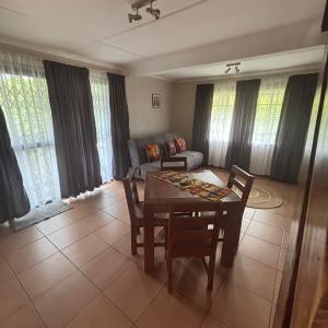 a living room with a table and chairs and a couch at The Rock & Root Guesthouse Self Catering in Nelspruit