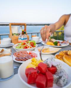a person eating food on a table with plates of food at Pinnacle Koh Tao Resort in Ko Tao