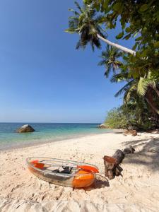 a boat sitting on the sand on a beach at Pinnacle Koh Tao Resort in Ko Tao