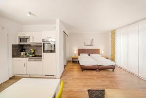 a living room with two beds and a kitchen at ADAPT APARTMENT HOTEL BERLIN - Adlershof in Berlin