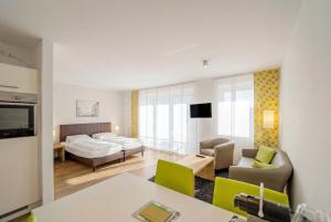 a living room with a couch and a bed and a living room at ADAPT APARTMENT HOTEL BERLIN - Adlershof in Berlin