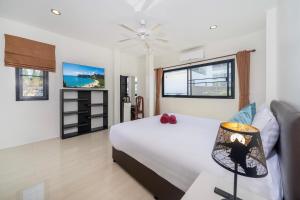 a bedroom with a bed and a table with a lamp at Rawai Escape 5BR Pool Villa Close to Everything in Ban Saiyuan (1) +31 photos
